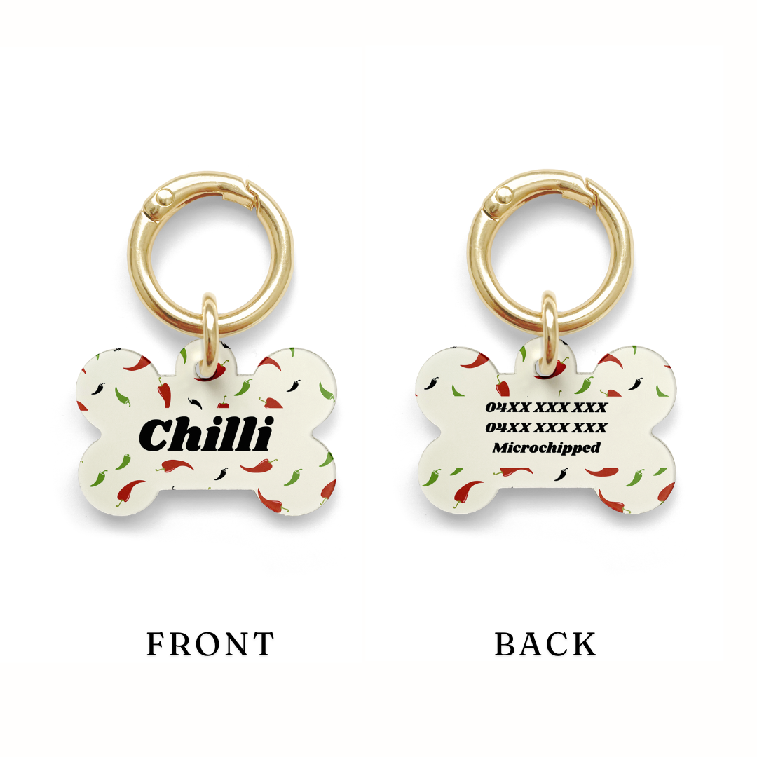 Example of contact details position on a Custom pet ID tag with a design showing green red and black chillies on a beige background with gold ring.