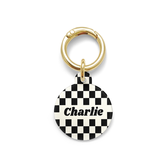 Black and white checkered Pet ID tag in a circle shape with a gold ring.