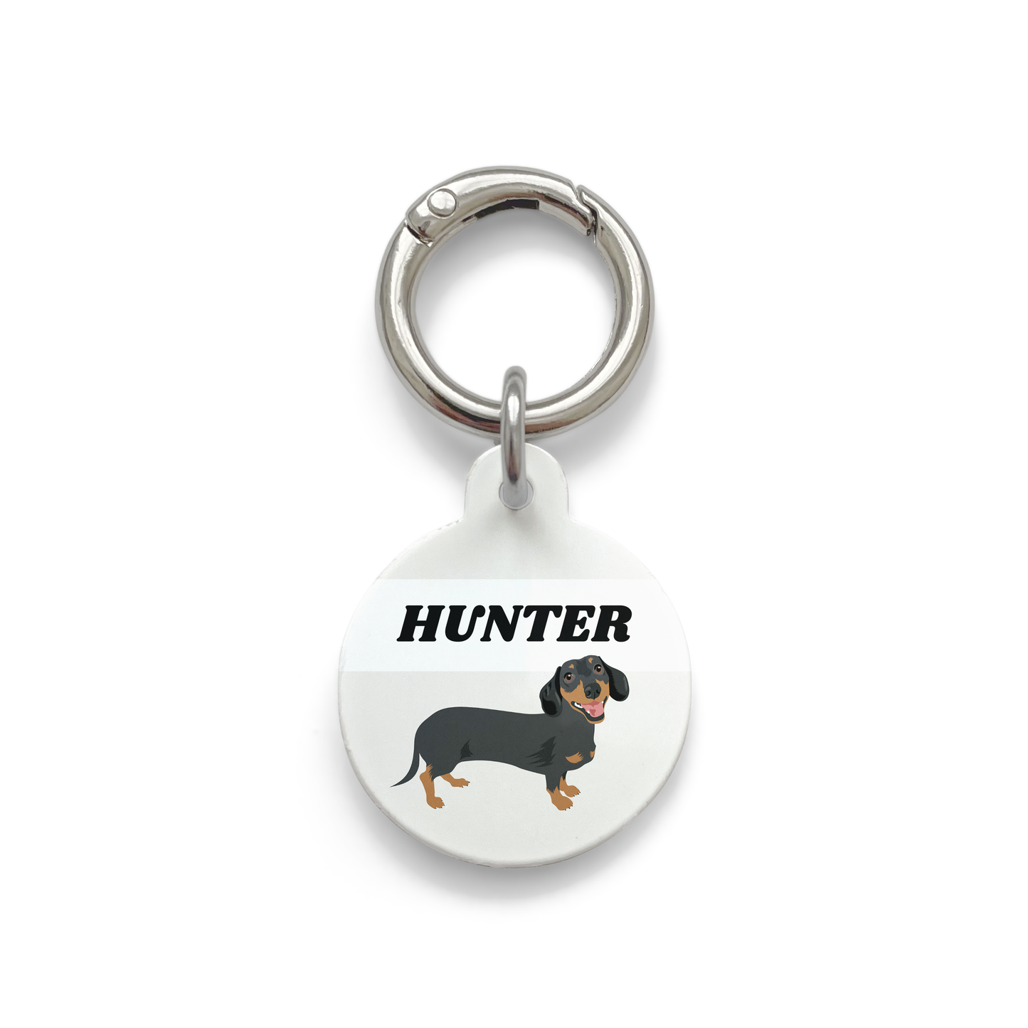 Black and tan dachshund illustration on a circular dog tag with a grey background and silver ring.