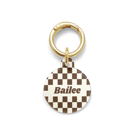 Brown and white checkered Pet ID tag in a circle shape with a gold ring.