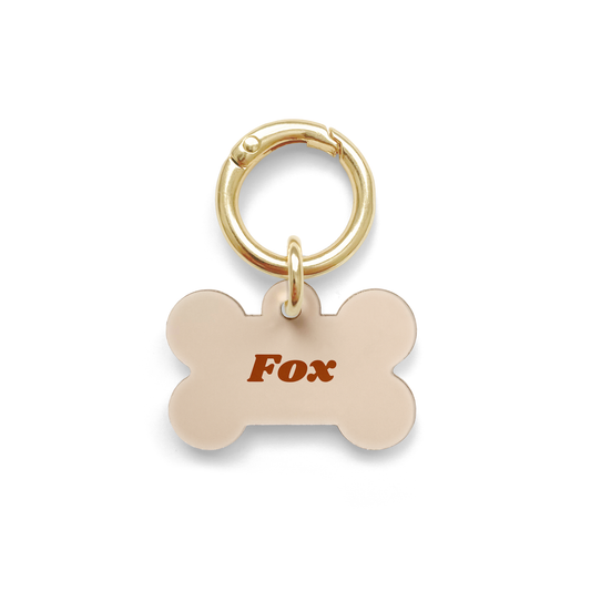 Beige Pet ID Tag in a bone shape with a gold ring.